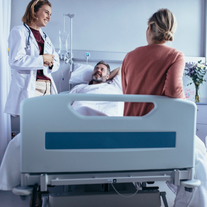 Man in hospital bed taking with provider