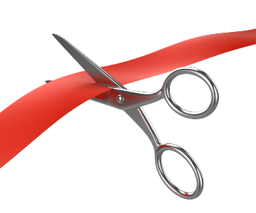Image of shiny silver scissors snipping a bright red ribbon