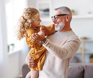 Senior man who attended Medicare annual wellness visit dancing with granddaughter