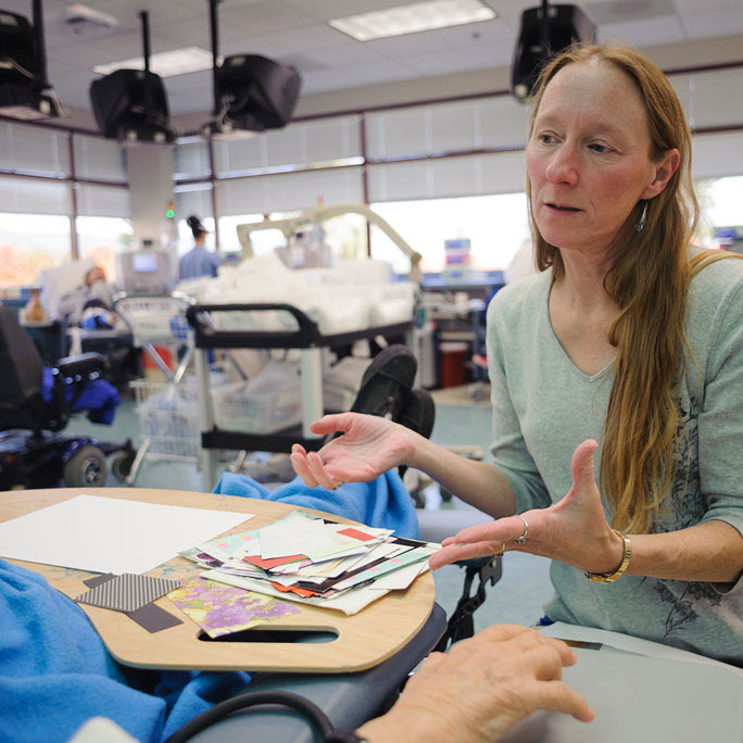 Person gesturing to a stack of colorful papers