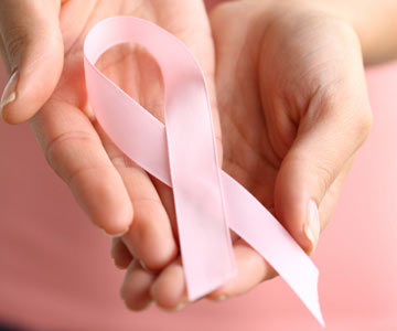 Hands holding a pink breast cancer awareness ribbon