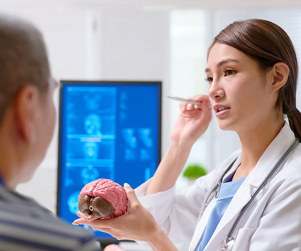 A physician performs an eye exam to evaluate a patient for concussion.
