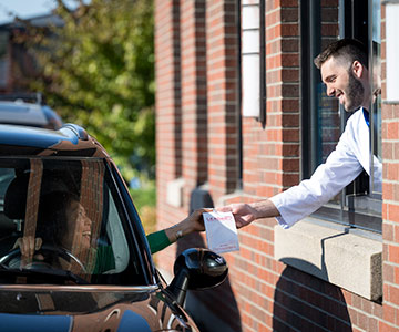 Lebanon pharmacist hand prescription to customer at the drive up window.