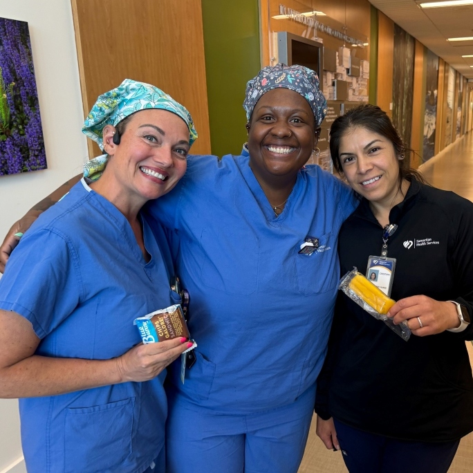 Samaritan employees stopping to smile in the hallway of one of Samaritan's five hospitals.