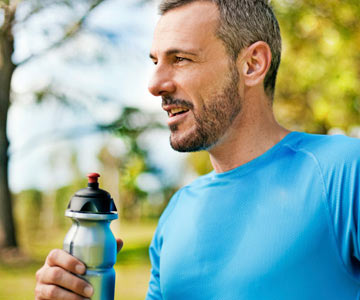 Middle-aged white male running with water bottle in hand