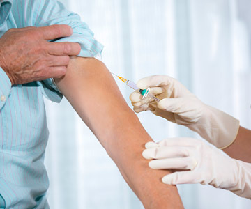 Vaccine being given to adult arm.