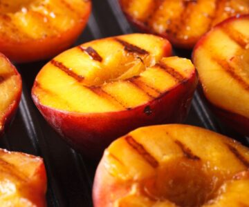 Grilled half peaches on a grill