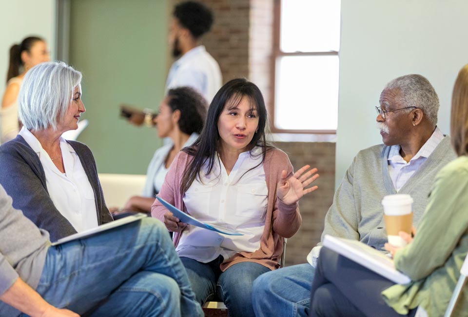 Woman speaking to group at an advisory council meeting.