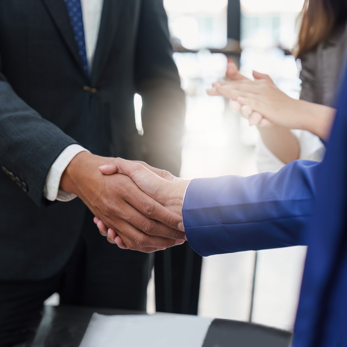 Close up of a handshake. Two people wearing professional business attire.