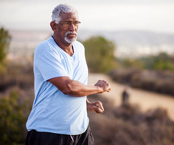 Man standing outdoors doing twisting stretch