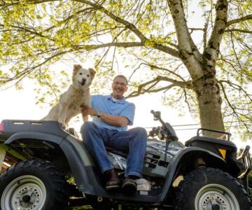 Dog and person on four wheel all terrain vehicle.