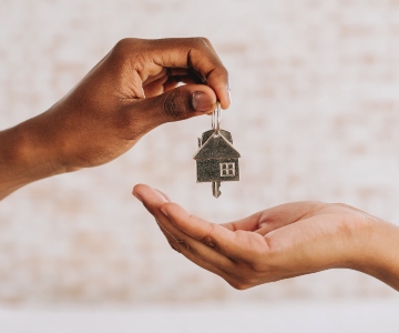 House keys being handed from one person to another.