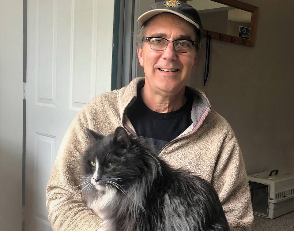Lynn's husband holding their cat.