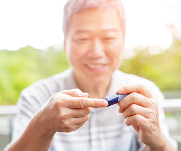 Man checking his blood glucose levels with a monitor.