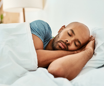 Man sleeping peacefully in his bed.