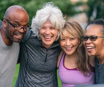 Four middle-aged friends gathered at an outdoor event.