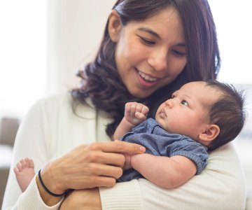 Smiling mom holding baby.