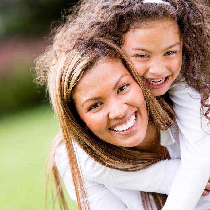 Mother and daughter piggyback.