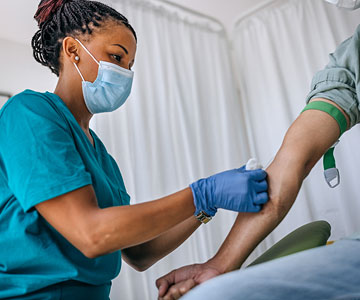 Phlebotomist performing lab work on patient