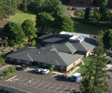 Aerial view of two roof lines and a parking lot at Mario Pastega House in Corvallis, Oregon.