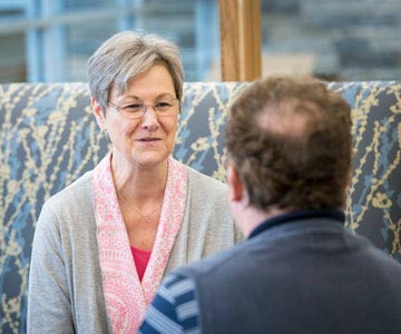 A mature woman and man converse at the Samaritan Pastega Regional Cancer Center in Corvallis, Oregon.