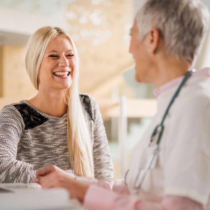 Patient laughing and shaking doctor's hand.