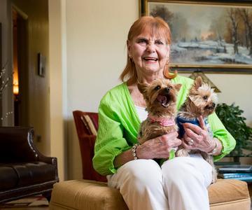 Heart valve replacement patient Patricia Fields sitting with her two Yorkshire Terrier dogs sitting on her lap.