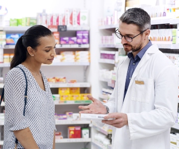 Male pharmacist consulting a female on a medication