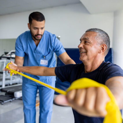 Physical therapist working with patient using resistant bands.