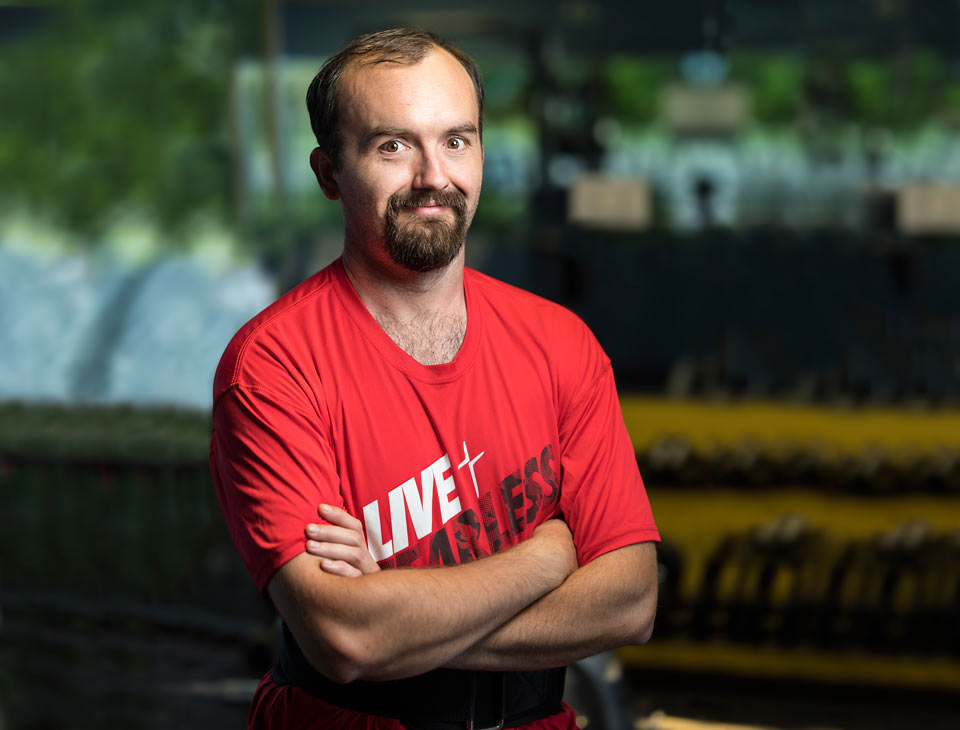 A smiling confident Anthony, arms folded in front of him.