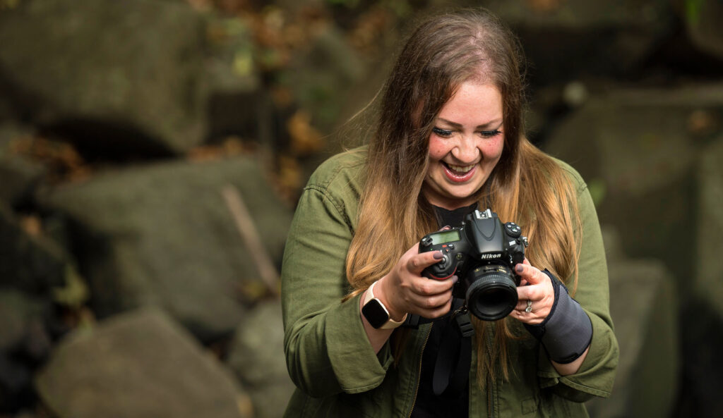 Ashley smiling as she reviews the images in her camera's video display.