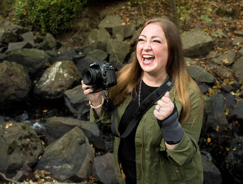 Ashley with an enthusiastic smile as she tells her subject that the picture looks great.
