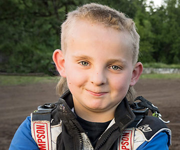 A close up of young Brody smiling at the race track.