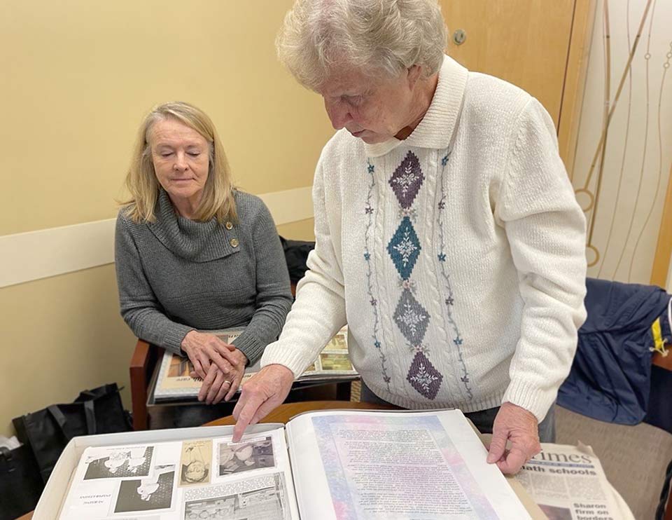 Carol and Joni look through a scrapbook together from their nursing careers at Samaritan.