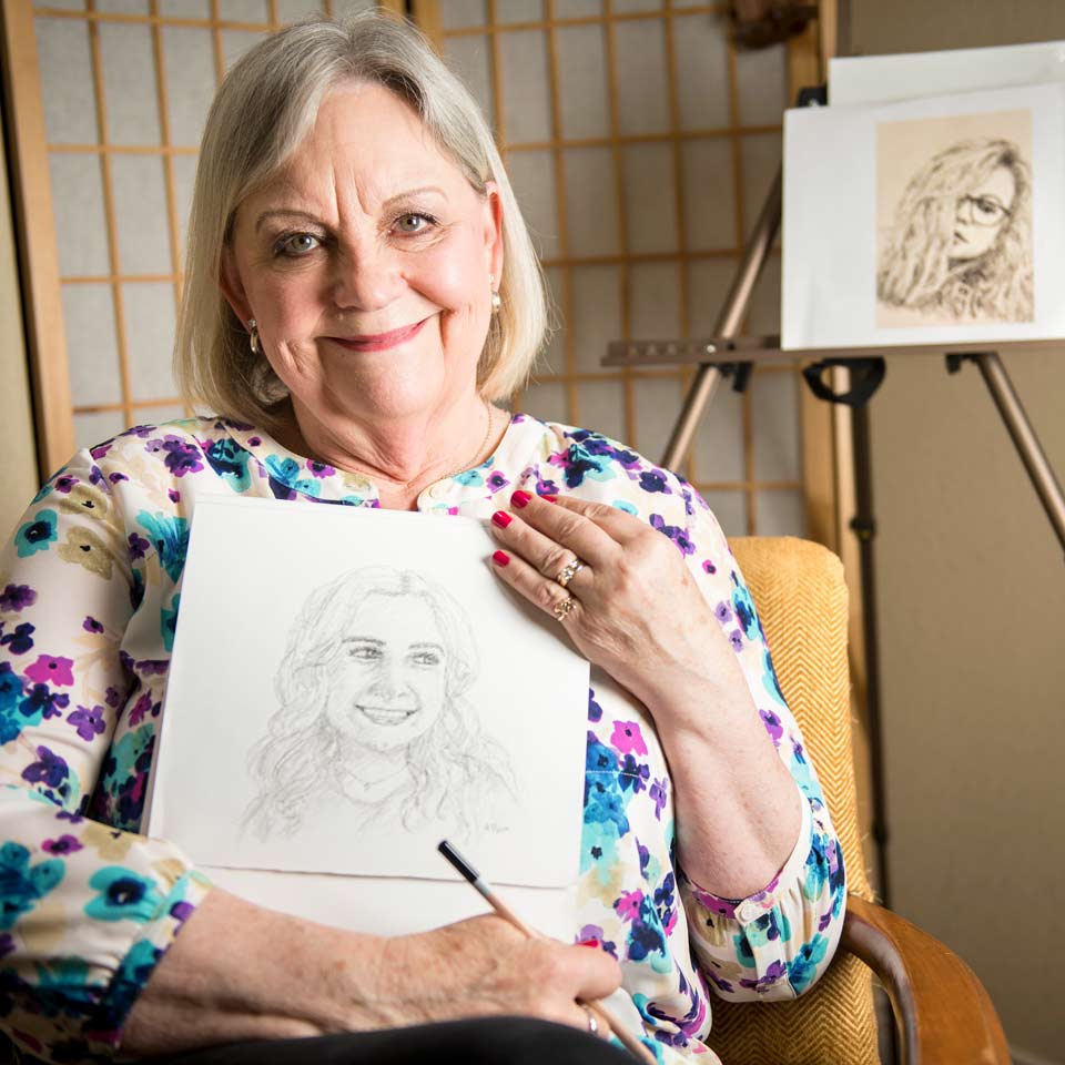 Donni holding a pencil sketch of her granddaughter.