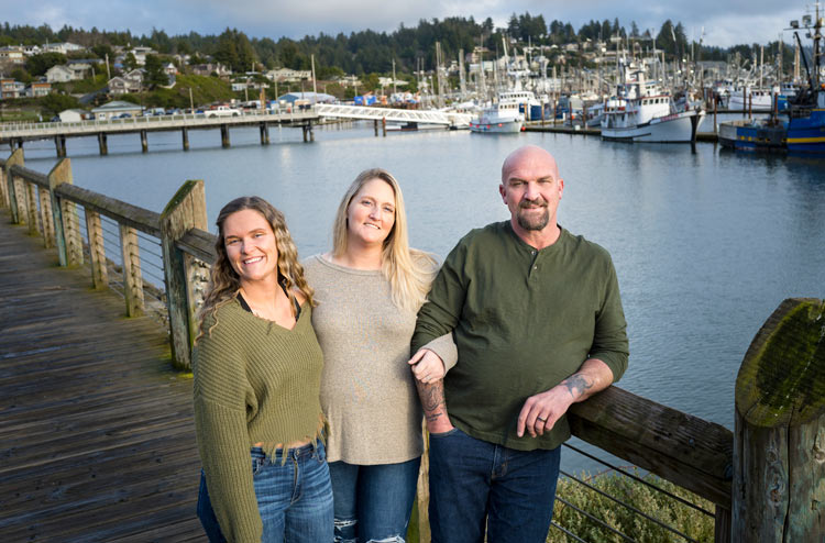 Gina with her family standing on a dock overlooking Yaquina Bay in Newport.