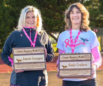 Jeanette and Sonia holding plaques for their annual Coast Busters event in Newport, Oregon.