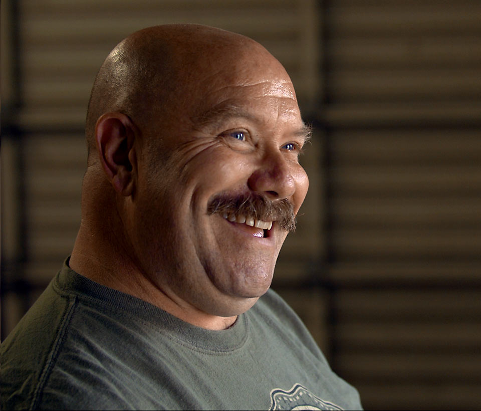 A close up of John laughing with a twinkle in his eye.