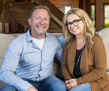 Close up of Kent and his wife smiling as they sit on a couch in their home.