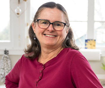 Lynn smiling in her cozy kitchen.