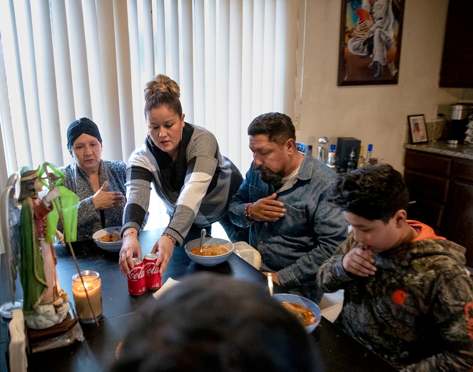 Maria's family sitting down to the family dining table to eat dinner.