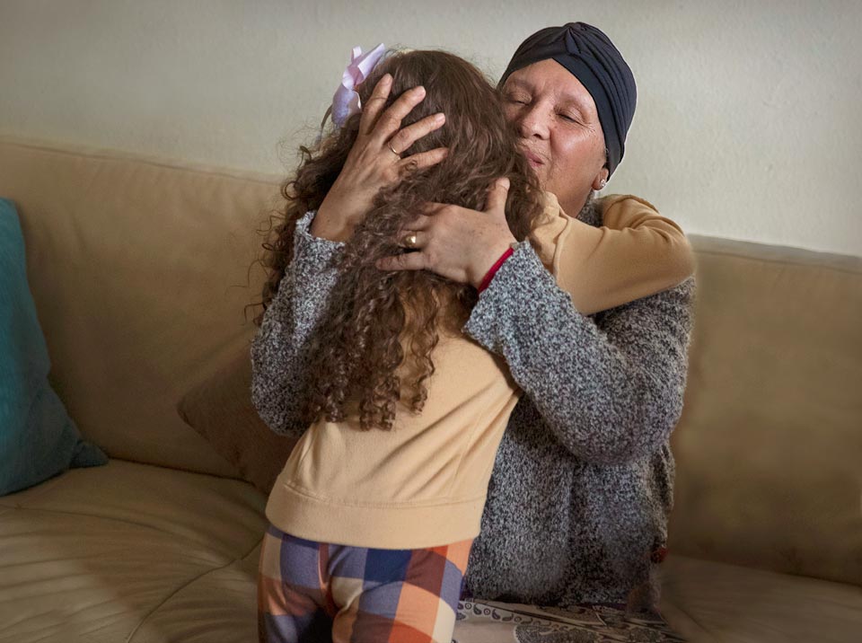 Maria hugging her grand daughter.