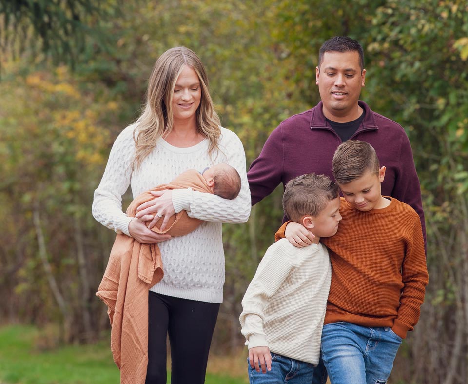 Mike and his wife with their three children walking with their three children.