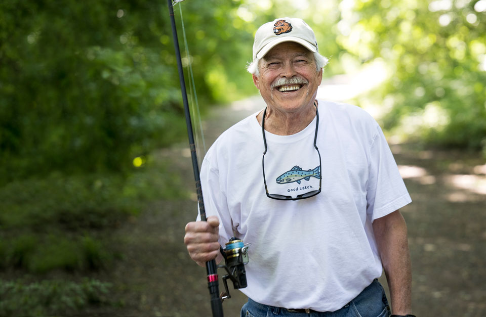 A smiling Randy with his fishing pole in hand.