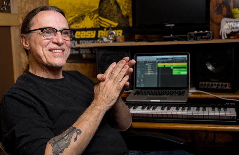 Rik at home in front of his electronic keyboard where he can often be found composing music.