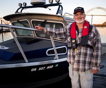 Roger standing next to his fishing boat on Yaquina Bay on Newport, Oregon.