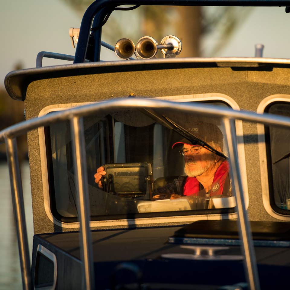 Roger at the helm of his boat as he prepares to go fishing.