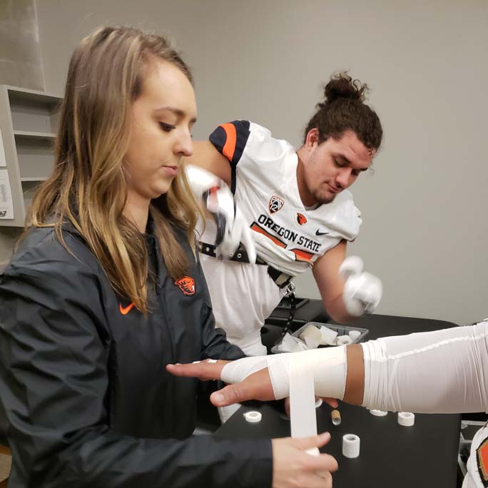 Clinician wraps injured hand with tape.