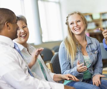 smiling young woman talking to a group.
