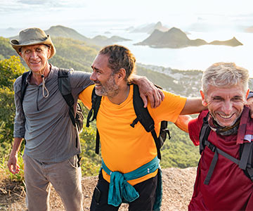 Three male friend on a hike above the ocean.